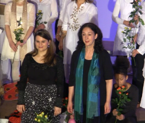Zwei Solistinnen mit Rosen im Schlussbild.
